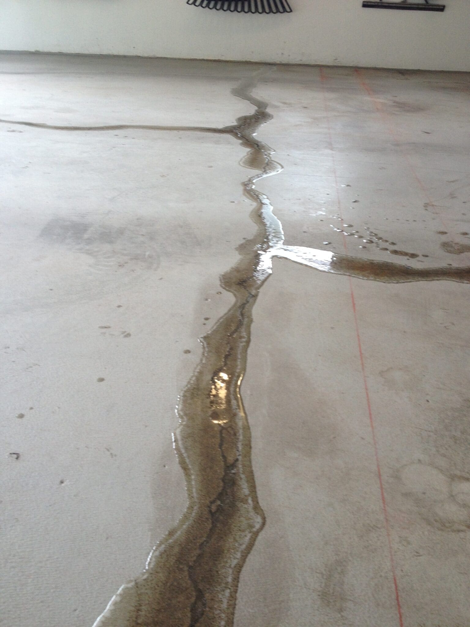 A crack in the floor of an unfinished building.